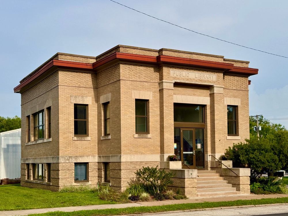 A nice yellowish brick building, very simple and boxy and symmetrical, two column around rectangular doorway 