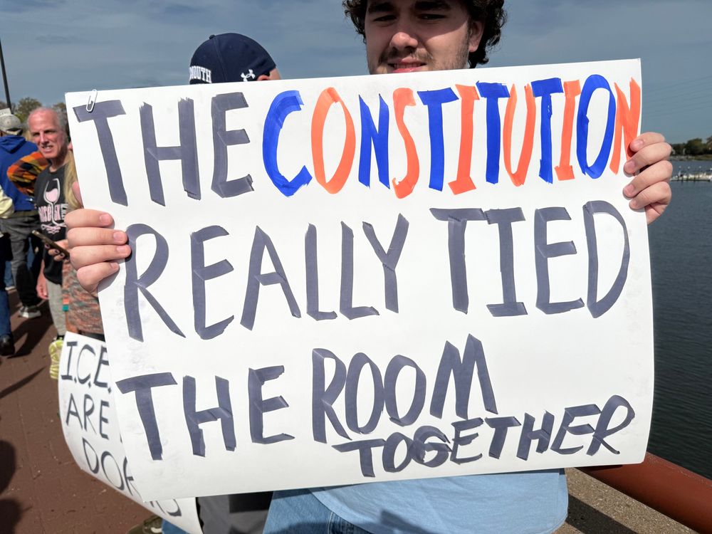 No kings protest poster that says “THE CONSTITUTION REALLY TIED THE ROOM TOGETHER”