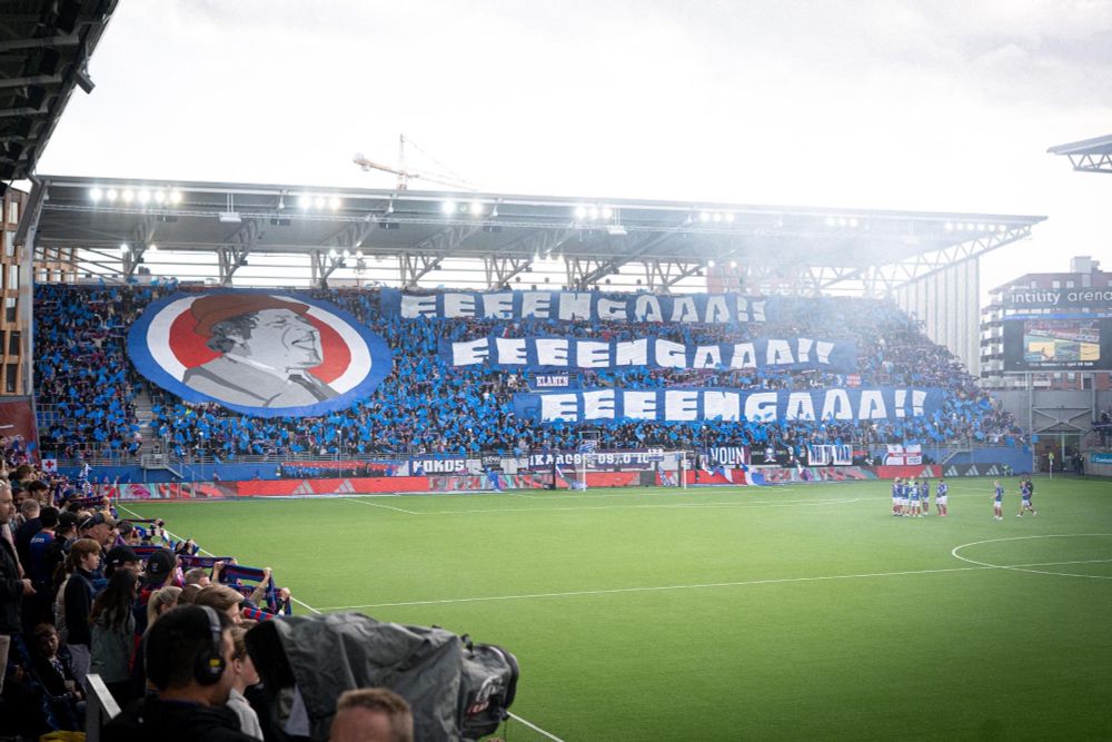 Tifo på østblokka. Tre store bannere som sier «eeengaaa!!» tre ganger. Stort banner av Fleksnes med rød, hvit og blå sirkel bak. 