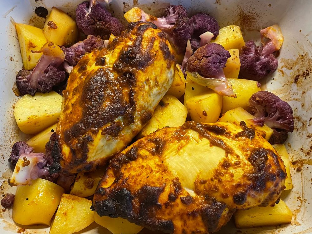 Backform mit Tikka-Hähnchen, Kartoffeln und lila Blumenkohl