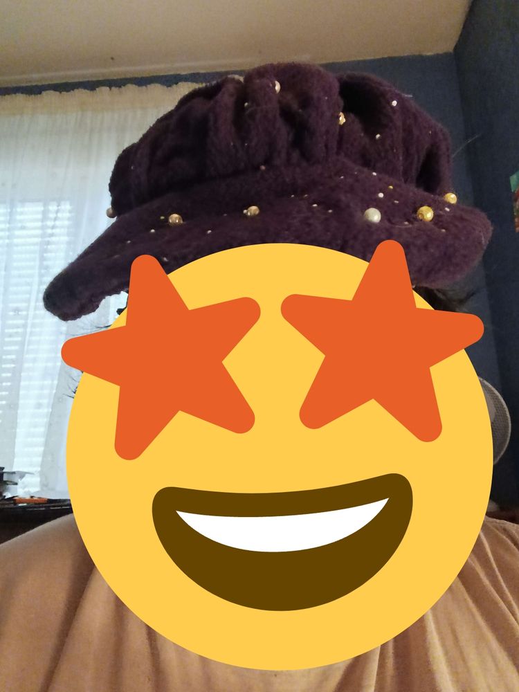 La casquette gavroche portée. Le visage de la personne est masqué par un émoji qui a les étoiles dans les yeux