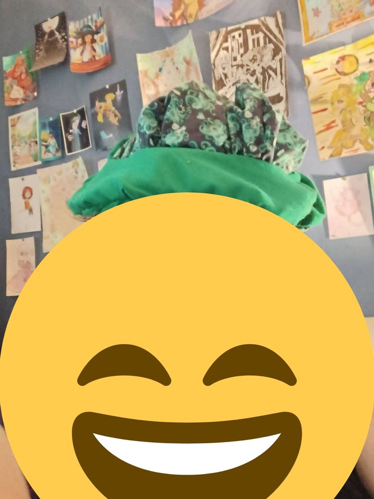 Casquette gavroche avec des motifs poulpes verts et bleus et du tissu vert. Vue de face étant portée. Un emoji masque le visage