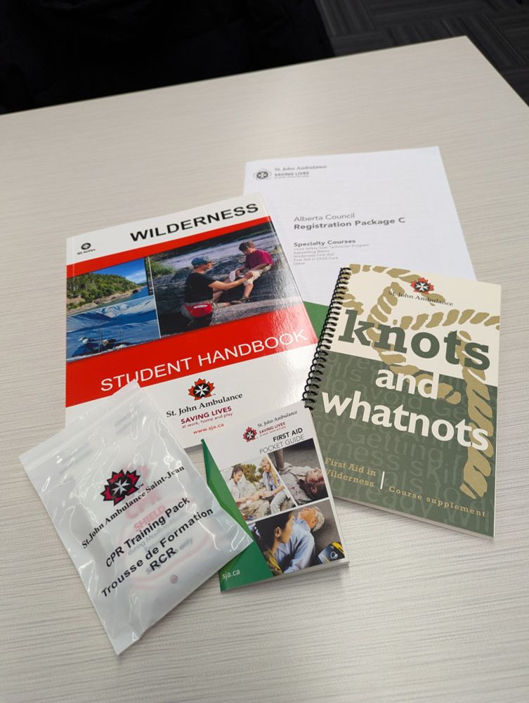 Supplementary material for the first aid course, including a handbook, registration form, pocket first aid guide and a booklet with additional material such as knit tying.