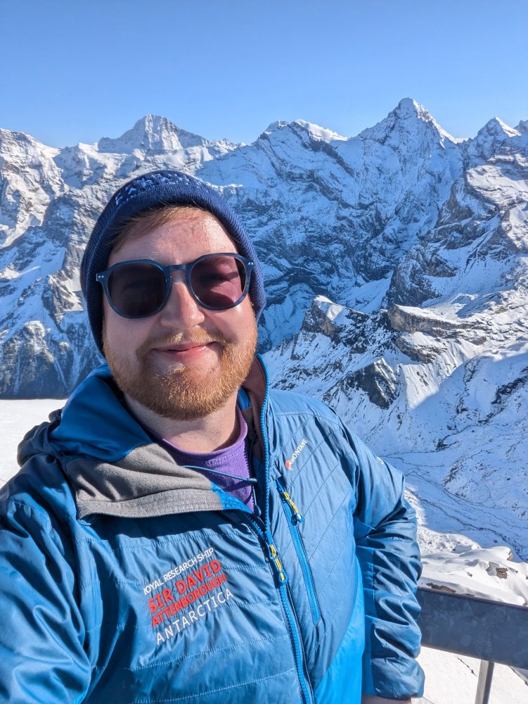Dylan stood in front of snow covered mountains in Switzerland.