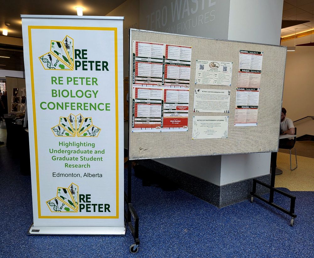 On the left there is a roll up banner stand that says "RE Peter Biology Conference: Highlighting Undergraduate and Graduate Student Research, Edmonton, Alberta". On the right there is a board with the schedule and notices from the conference. 