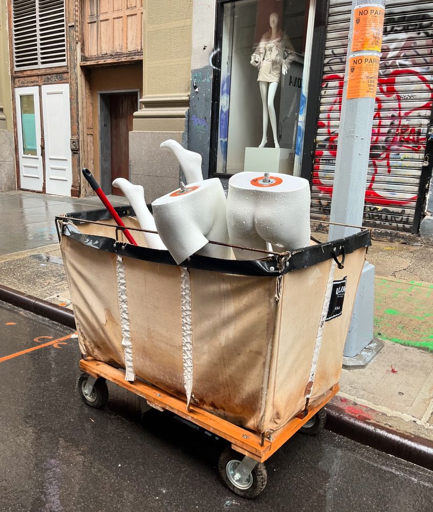 Leg mannequins stick out of a cart on a rainy NYC street. 