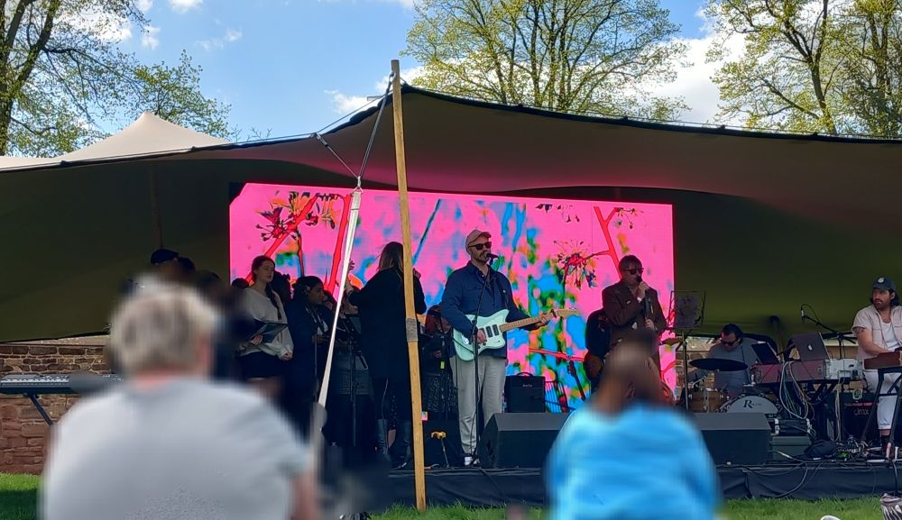 Simon Armitage and LYR performing on an outdoor stage