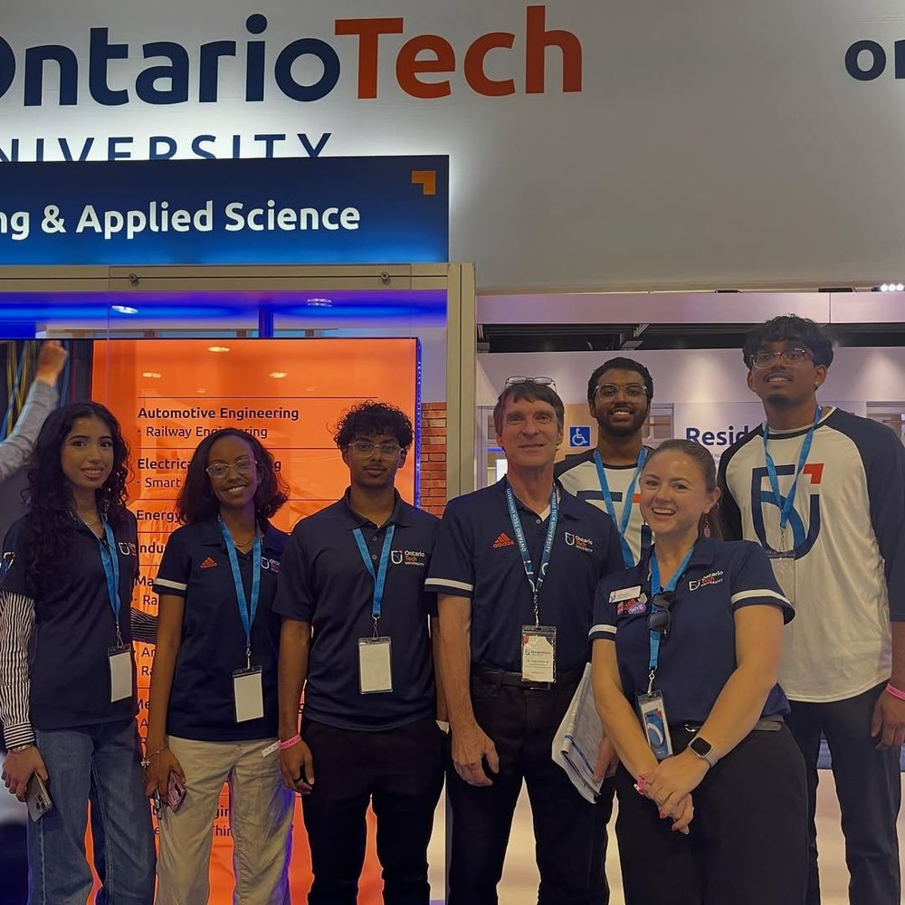 seven people pose together at the Engineering and Applied Science section of the Ontario Tech booth at the Ontario Universities' Fair
