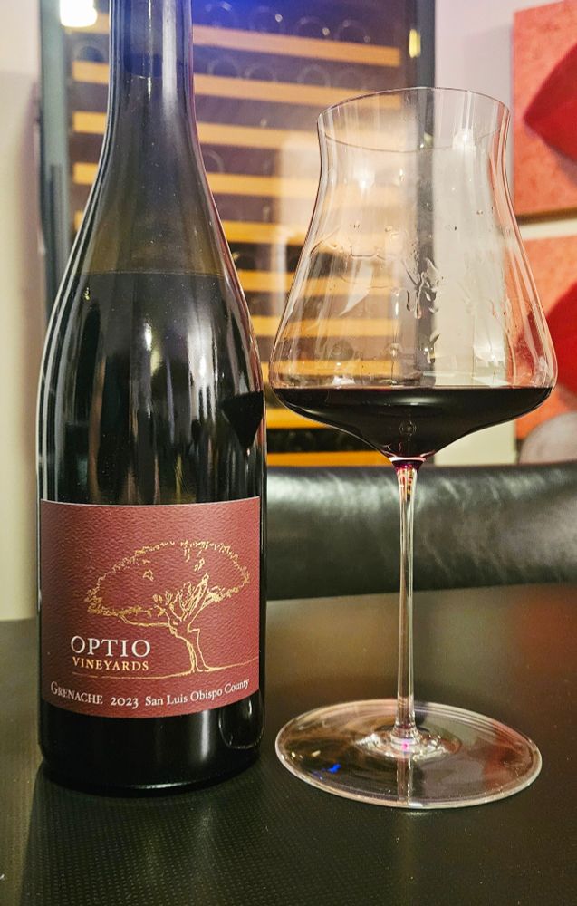 Optio Vineyards Spanish Springs Vineyard Grenache 2023, San Luis Obispo, California

Very pretty color of purple with a wide purplish rim and medium plus intensity.

Strong nose of red and black fruits with light wood, chocolates, herbs, earth, tobacco leaf and red candy.

Medium plus in body with medium plus acidity.

Dry on the palate with raspberries, cherries, spices, light oak, licorice, chocolates, sweet tobacco and peppercorn.

Tangy finish with fine grained tannins and tangy cranberries.

This is an easy drinking Grenache from San Luis Obispo in California. Fruit forward and engaging, with nice complexity and a soft mouthfeel. 

Good right out of the bottle and good by itself or with food. 

Will continue to age nicely in the next 5 to 7 years. Would be nice to revisit it in 3 years and see how it evolves. 

This Single Vineyard Grenache is easy drinking, elegant and nicely balanced. Tangy and better with a light chill. 
 
Paired nicely with hard cheeses. 

A blend of 76% Grenache and 24% Syrah. Aged for 16 months in (40% new) French Oak barrels. A small production of only 1,200 bottles. 

14.5% alcohol by volume.

90 points. 

$62.

