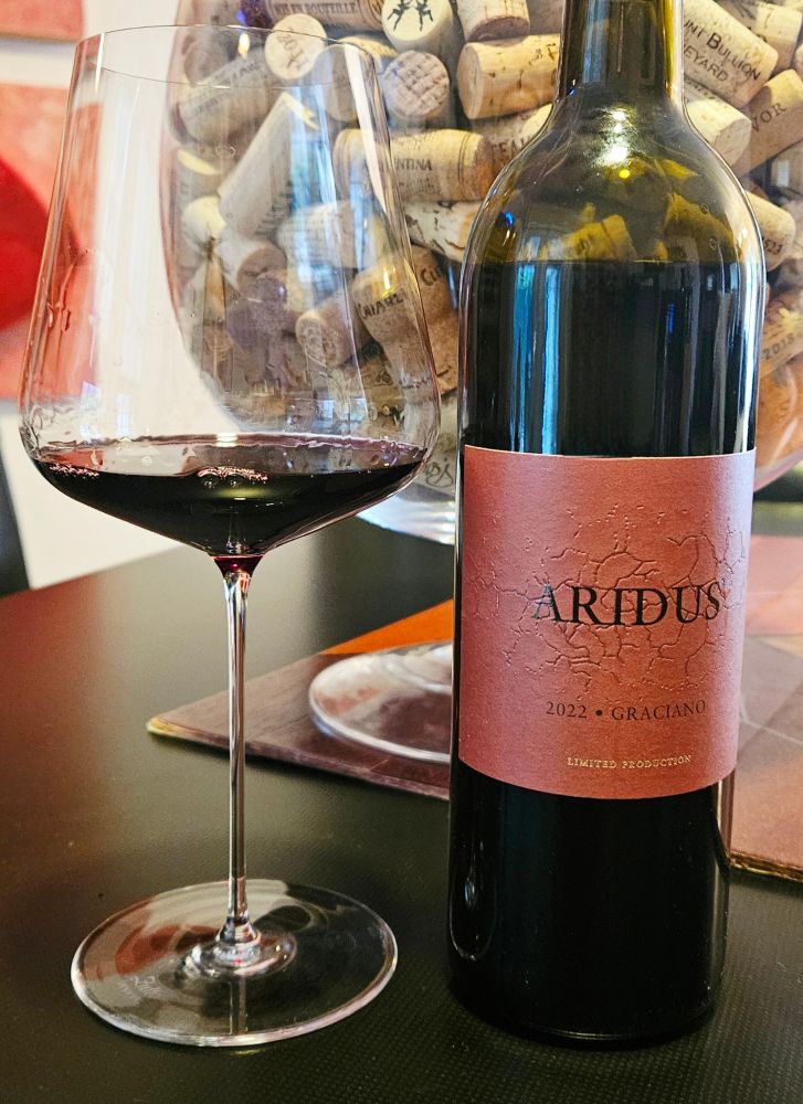Aridus Wine Company Limited Production Graciano 2022, Arizona 

Ruby in color with medium plus intensity and a wide reddish rim. 

Light nose of pomegranates, cranberry juice, black pepper, wild flowers, chared coffee and spices. 

Medium plus in body with medium acidity.

Dry on the palate with raspberries, currants, plums, fresh cherries, light oak, spices, chocolates, tobacco, bitter herbs, earth and peppercorn.

Medium length on the finish with fine grained tannins and tangy cranberries.

This is a tasty Graciano from Arizona. Very spicy and rich. 

Fruit forward and elegant. Smooth and soft. Showing nice complexity with a soft mouthfeel.

Needed 2 hours to open up properly, so be patient. Would be nice to revisit it in 5 years and see how it evolves. The high alcohol is not too noticeable. 

A good food wine, tangy and interesting. 

100% Graciano grapes were aged in neutral oak barrels for 15 months. A small production of only 2,700 bottles. 

16% alcohol by volume.

90 points.

$65.