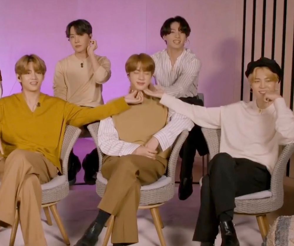Taehyung, Hobi, Jungkook, Jimin, and Jin. Taehyung and Jimin are pinching under Jin’s chin. 
