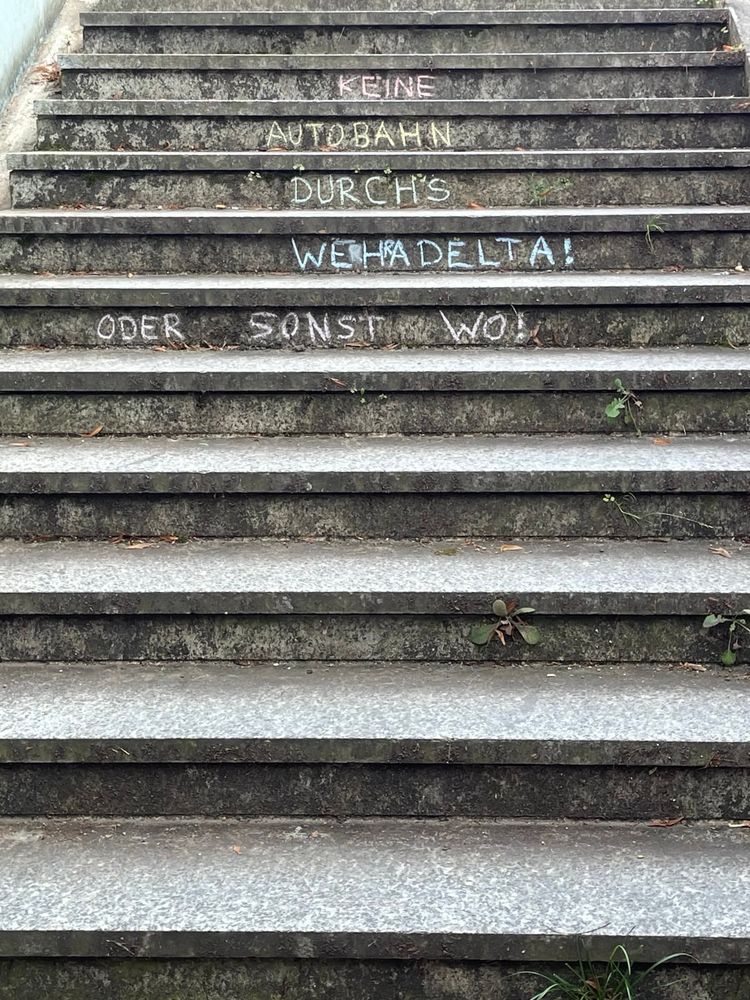 Treppe nach oben mit Kreide-Aufschrift Keine Autobahn durchs Wehradelta oder sonst wo!