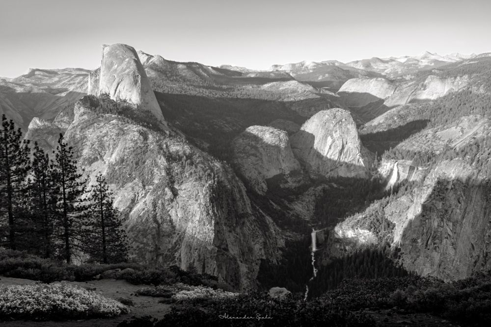 A black & white photo of Yosemite Valley from the Washburn Point. Notable landmarks include Half Dome on the left and Liberty Cap, Vernal Falls, and Nevada Falls on the right.