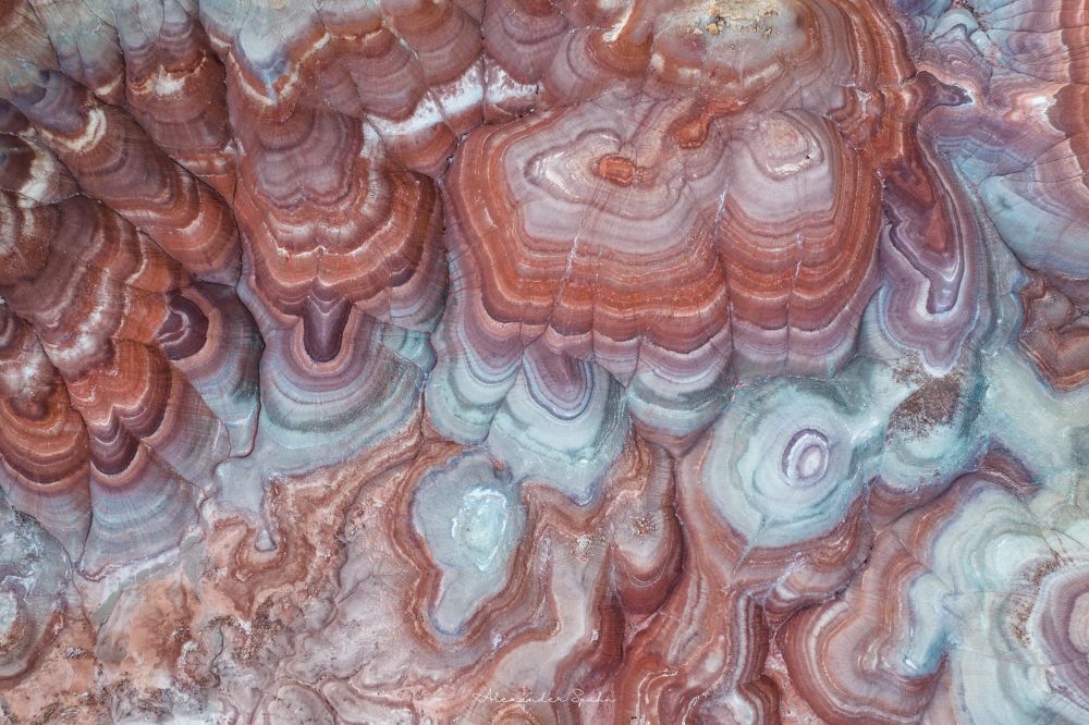 An aerial view of banded hills in the Utah desert. There are layers of red, magenta, white, orange, gray, and even blue*

The blue is actually gray, but appears slightly blue from above at blue hour.