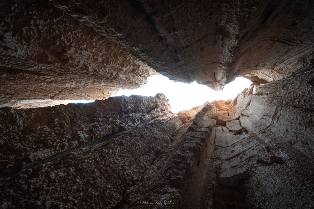 A photo taken from well within one of the narrow erosional corridors within the bentonite clay, looking straight up toward the sky.