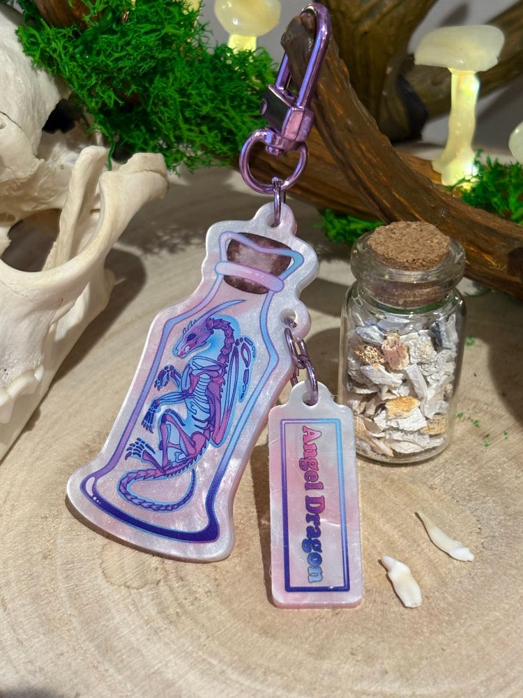 An acrylic charm of a diaphonzised wet specimen angel dragon jar with a tag