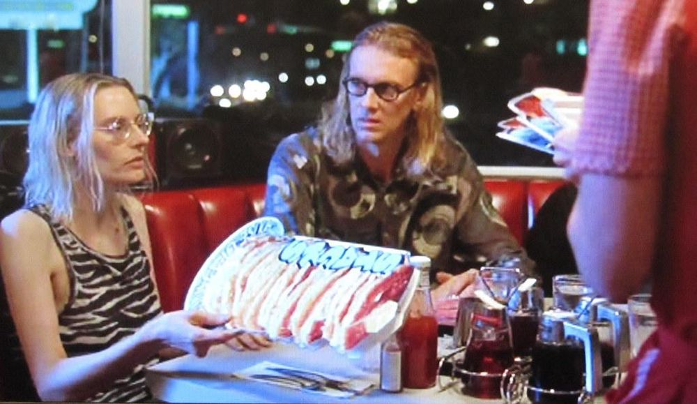 Aimee Mann handing over the menu after ordering pancakes in The Big Lebowski (1998).