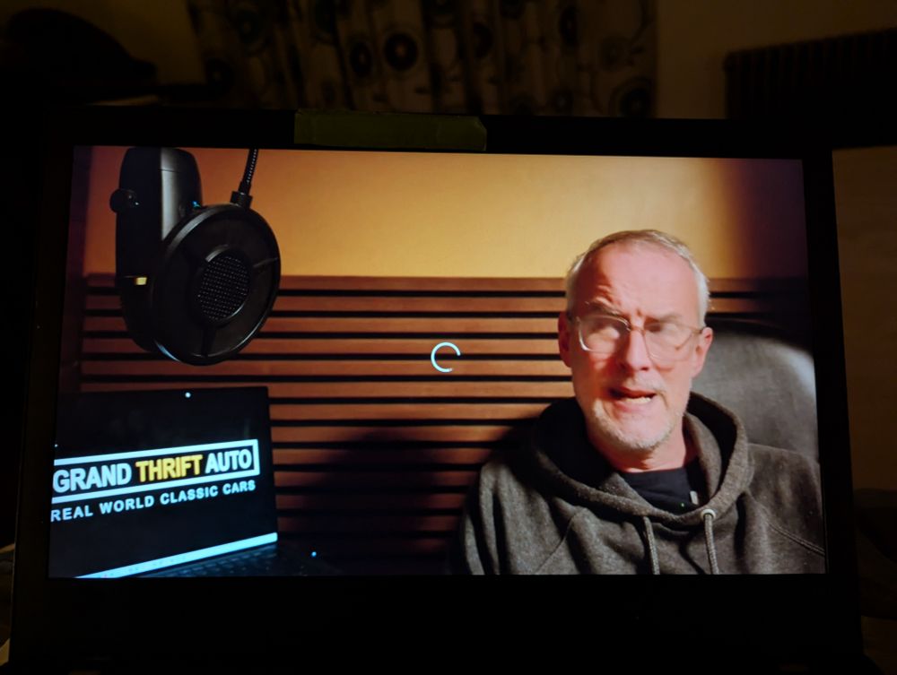 Picture of my frozen laptop screen. The presenter has his eyes closed and mouth half open. It is not a flattering picture. 