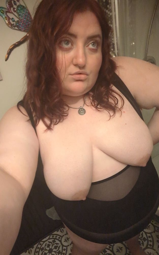 Divine standing in the bathroom with shapewear on
