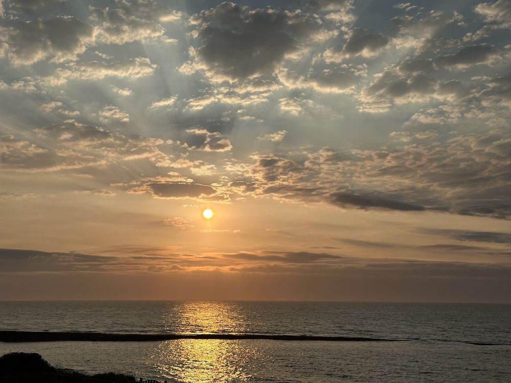 Sunrise blush, rain clouds, over a flat sea