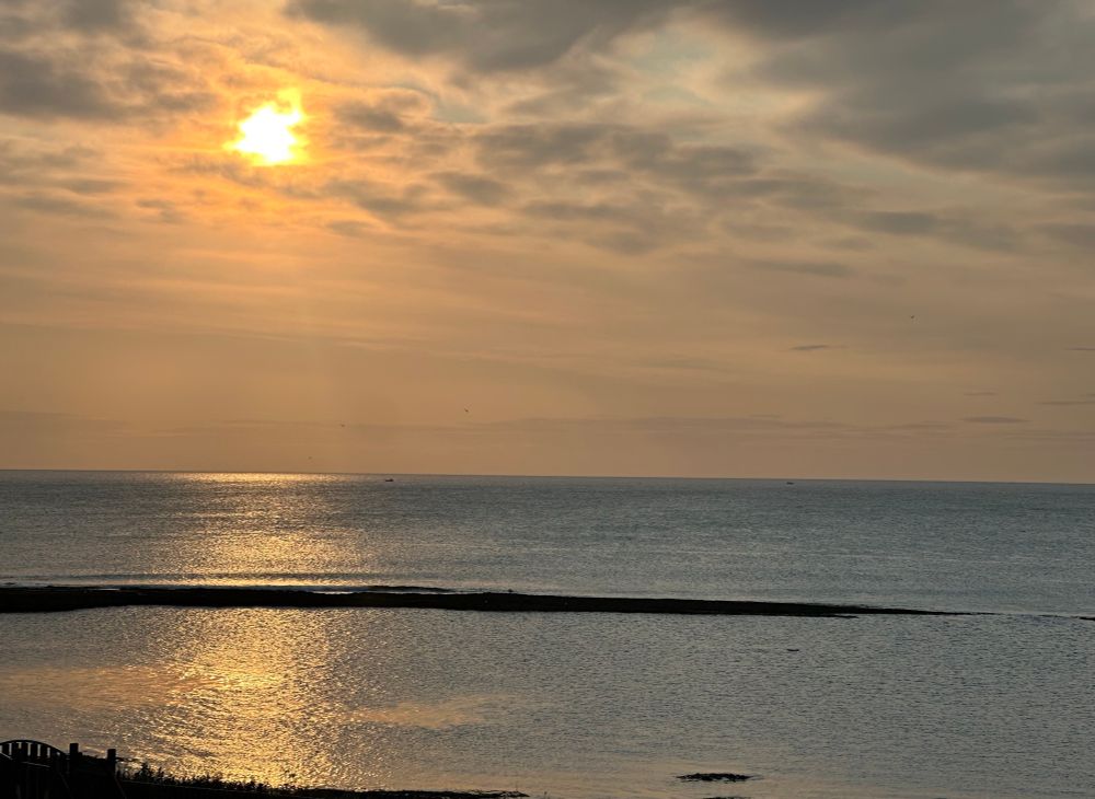 Post sunrise , peachy glow over flat sea. Craster