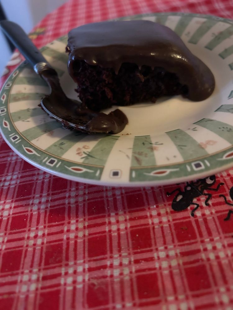 Cut piece of chocolate wacky cake with homemade chocolate icing from a Depression Era recipe.