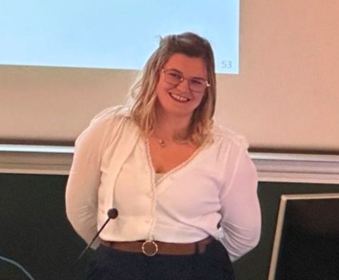 picture of Amelie Paquet after her succeful PhD defense in front of white board