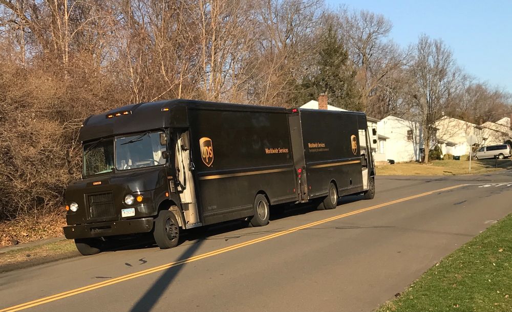 Two UPS trucks getting cozy together.
