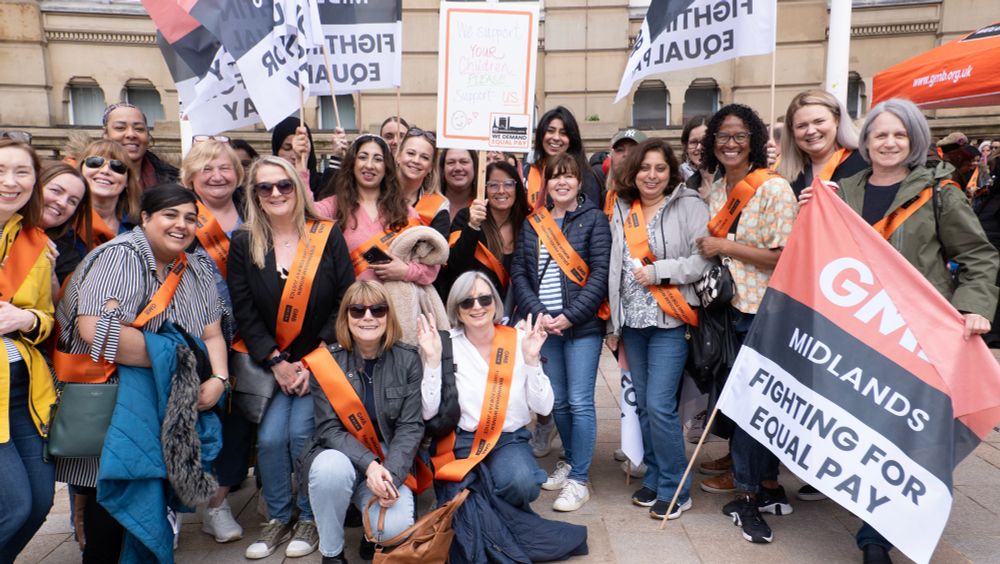 Birmingham City Council workers rally outside the city’s Council House with GMB flags and placards calling for equal pay. They are wearing GMB branded orange sashes that call for “pay justice”.