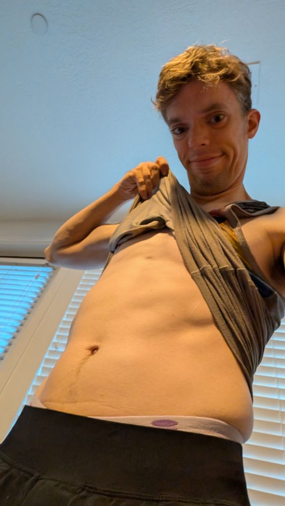 Me flexing my abs and showing off my muscles with my tanktop raised up.