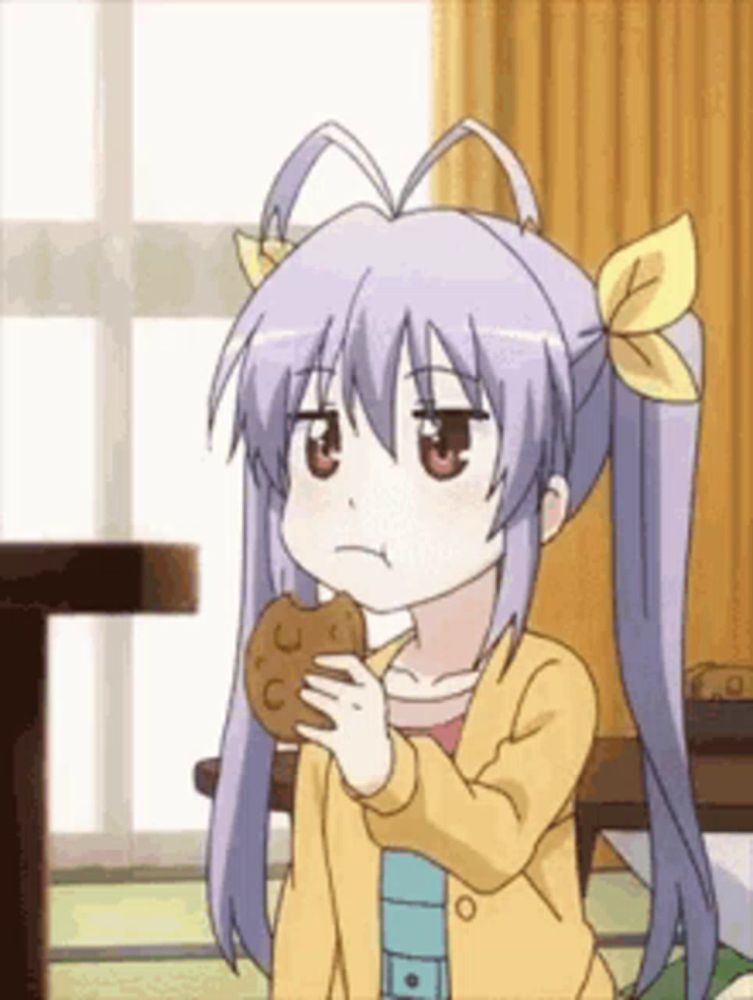 a girl with pigtails is holding a cookie in her hand .