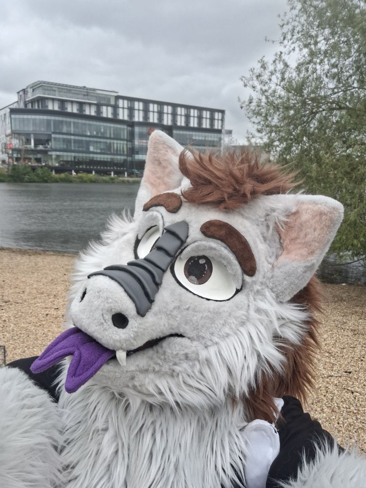 a fluffy dragon fursuiter taking a selfie outside of resorts world in birmingham