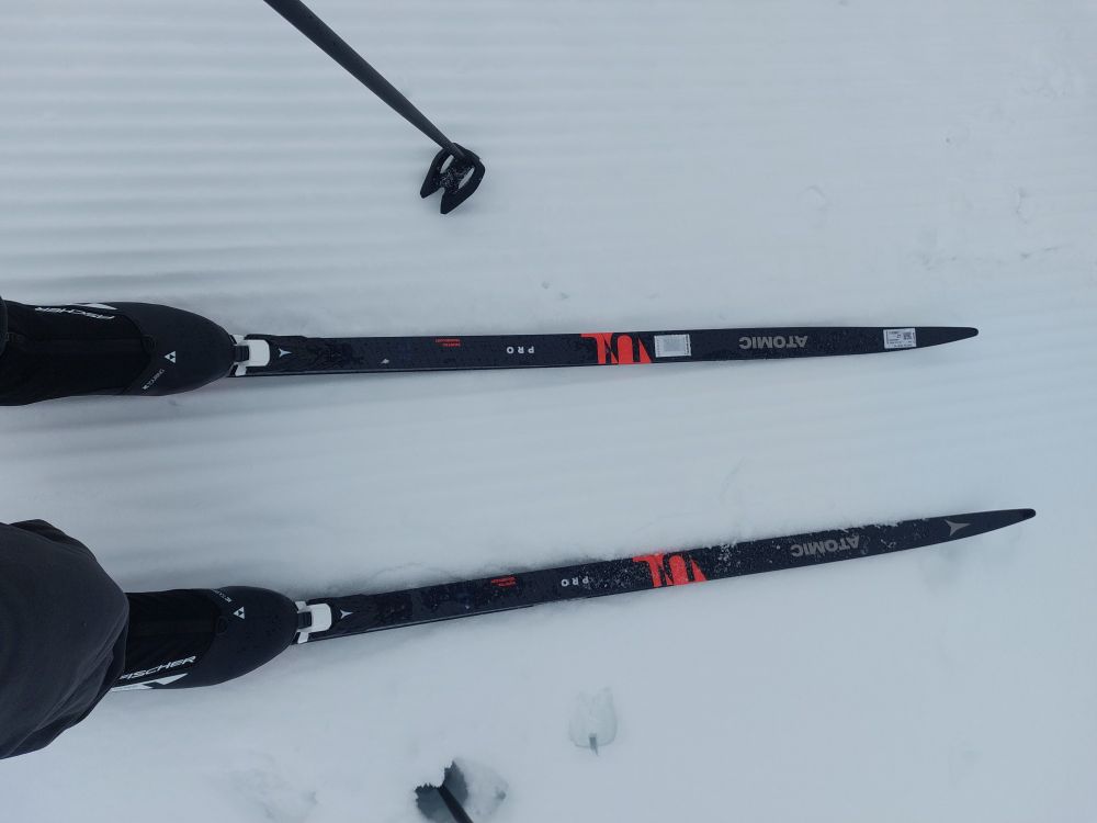 Picture of front half of pair of Cross country skis on trail showing boots and poles