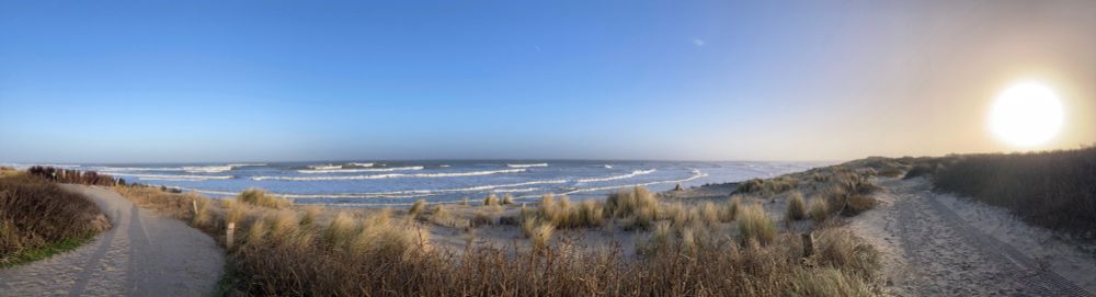 Blick von den Dünen auf die Nordsee. Im rechten oberen Bildrand die tief stehende Wintersonne
