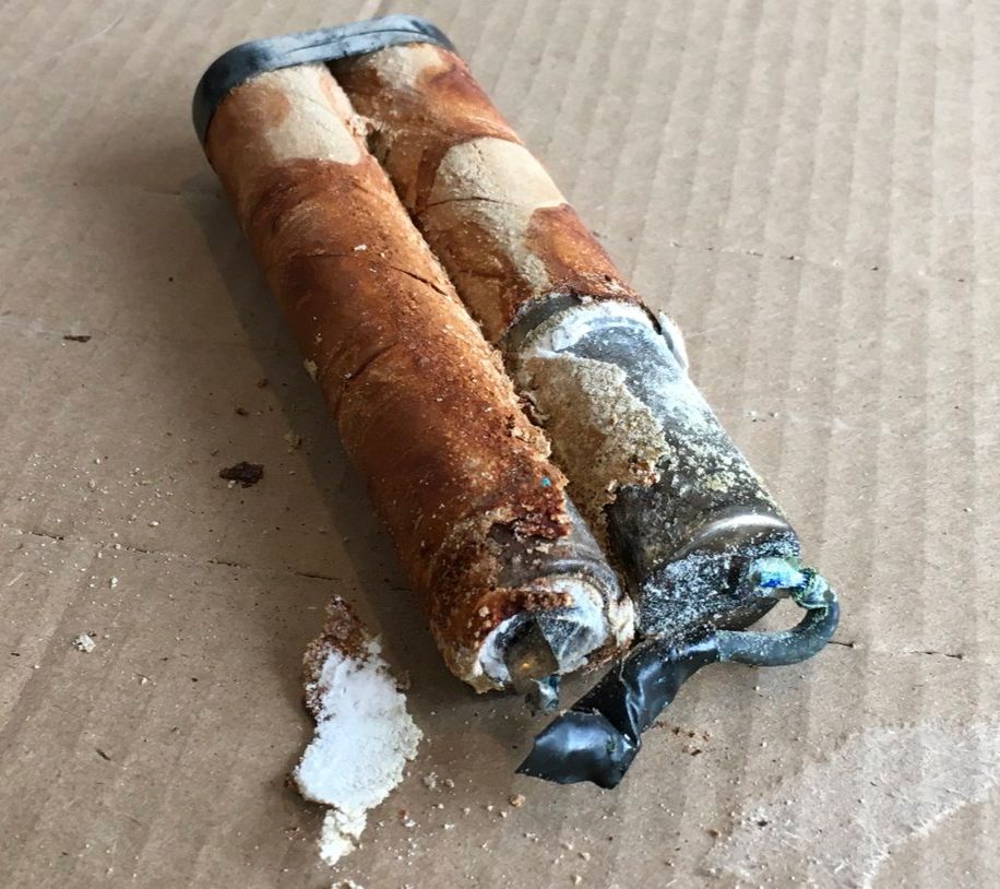 the same battery with its plastic sheath removed. revealing battery goo soaked and rotting cardboard tubes surrounding leaking metal cans and blue corroded wires.