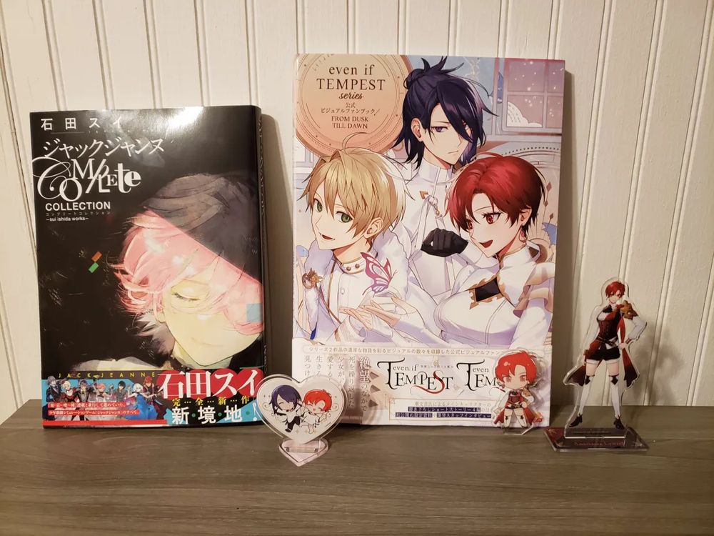 The artbooks for Jack Jeanne and even if TEMPEST. There are some acrylic stands of Anastasia Lynzel and Tyril I Lister (characters from even if TEMPEST).
