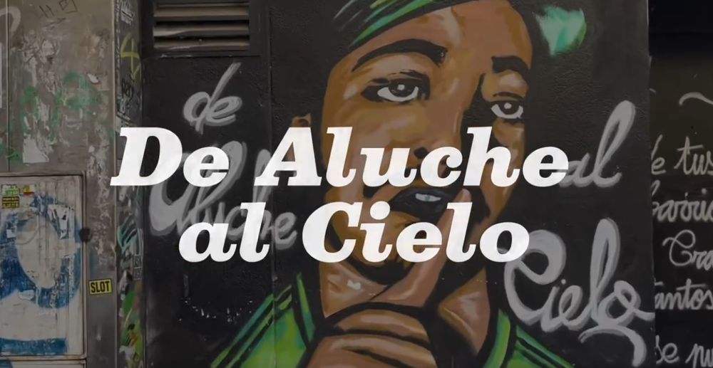 Imagen ilustrativa de la canción "De Aluche al Cielo" donde se ve ese texto escrito sobre un fondo de graffiti.