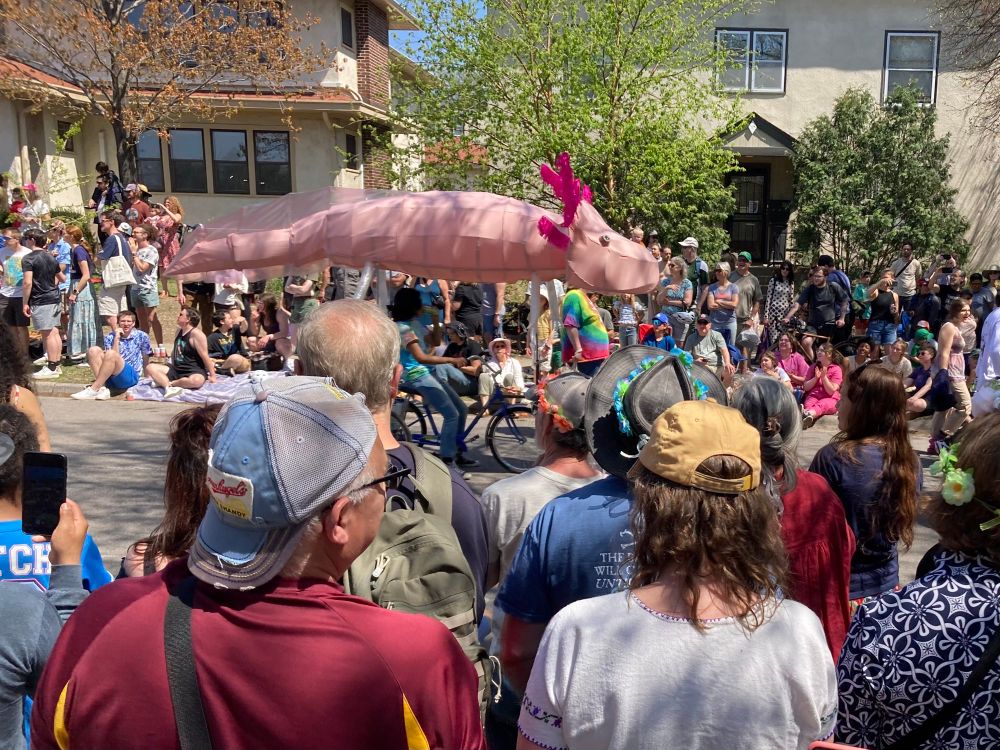 parade crowd watching an axolotl float go by