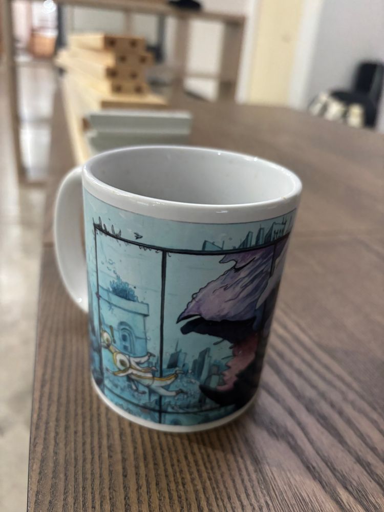 A coffee cup with artwork by Farel Dalrymple. 