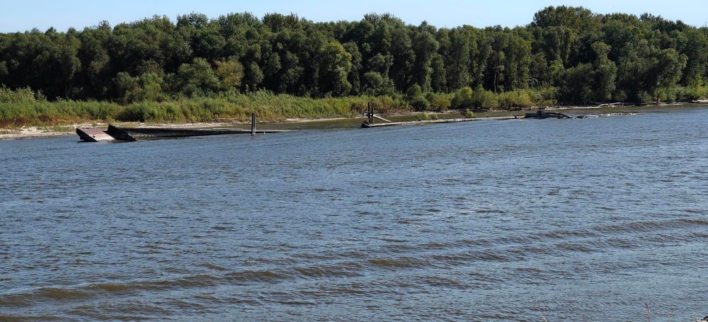 Two barges, mostly submerged, along the banks of the Upper Mississippi River near South Saint Paul, Minnesota.