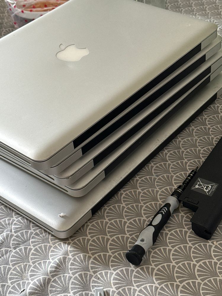 5 gestapelte, alte MacBooks 