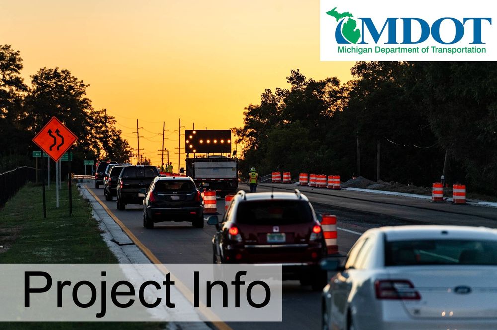 Cars driving at dusk in a work zone.