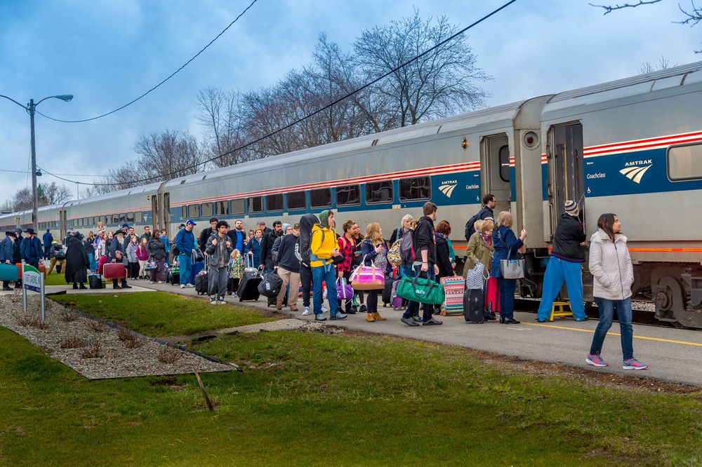 People lined up to get onto an Amtrak train.