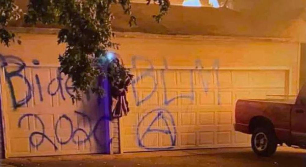 Garage spray painted to say BIDEN 2020, BLM, & a really sad suburban attempt at an anarchy symbol