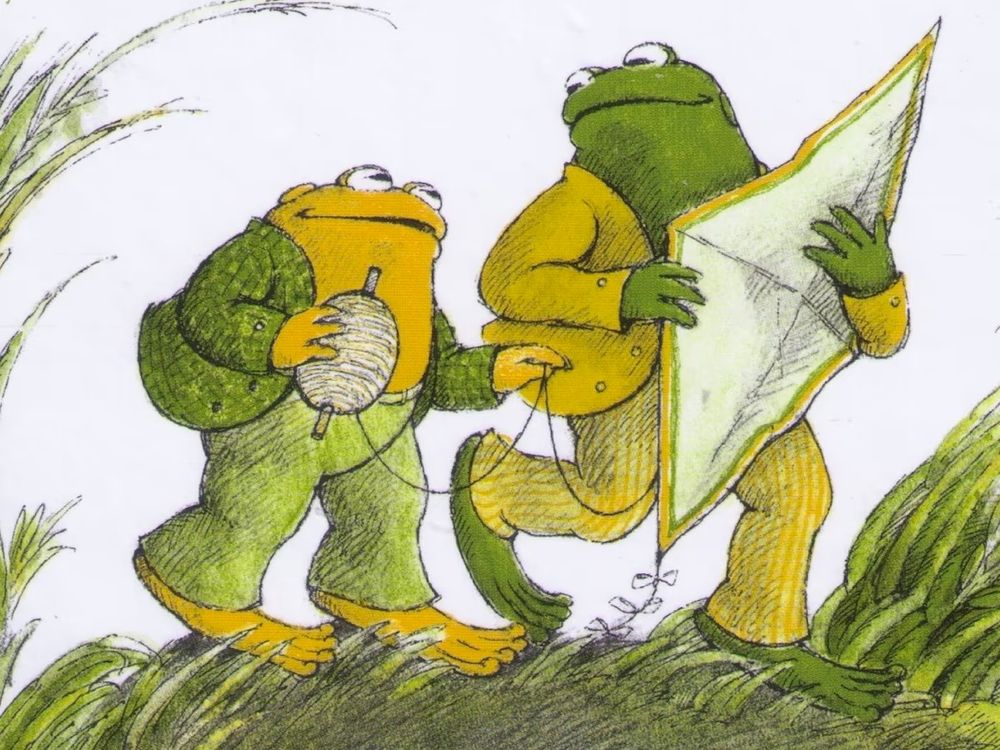 frog & toad looking lovingly at each other; toad holding kite string & frog holding the kite