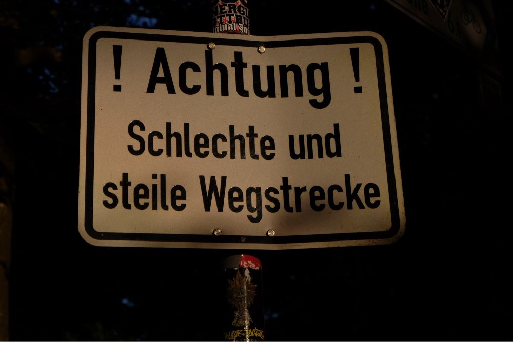 Hinweisschild mit dem Aufdruck: Achtung! schlechte und steile Wegstrecke