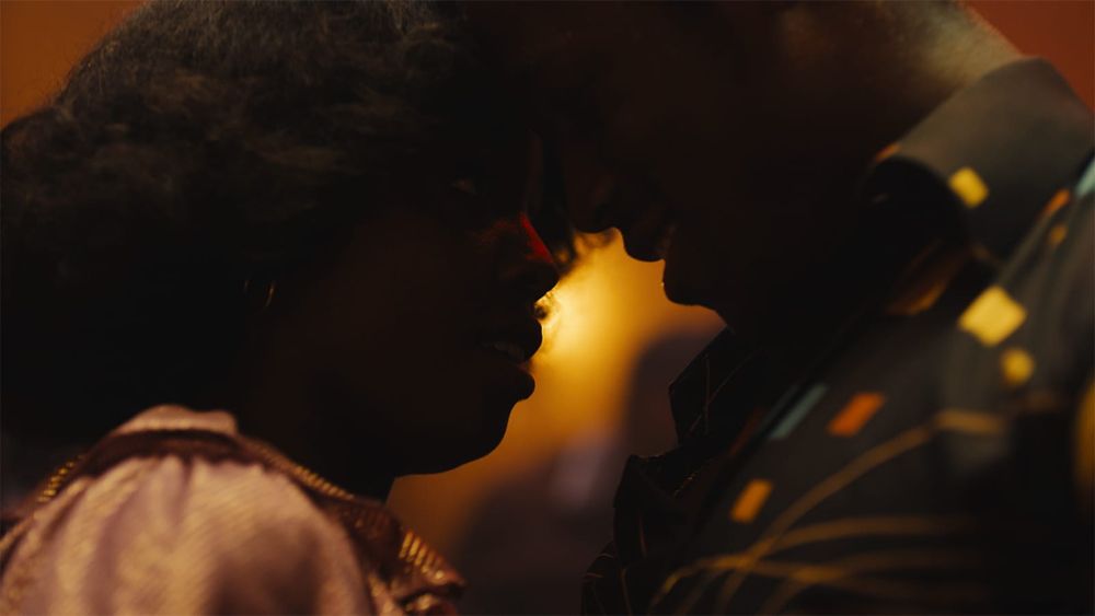 um casal dançando bem juntinho na contraluz