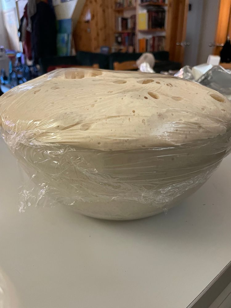 Bread dough overflowing out of the mixing bowl