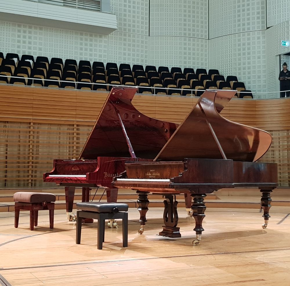 Zwei Flügel auf der Bühne des KKL, hinten ein roter moderne Bösendorfer, vorn ein kleinerer historischer von Blüthner