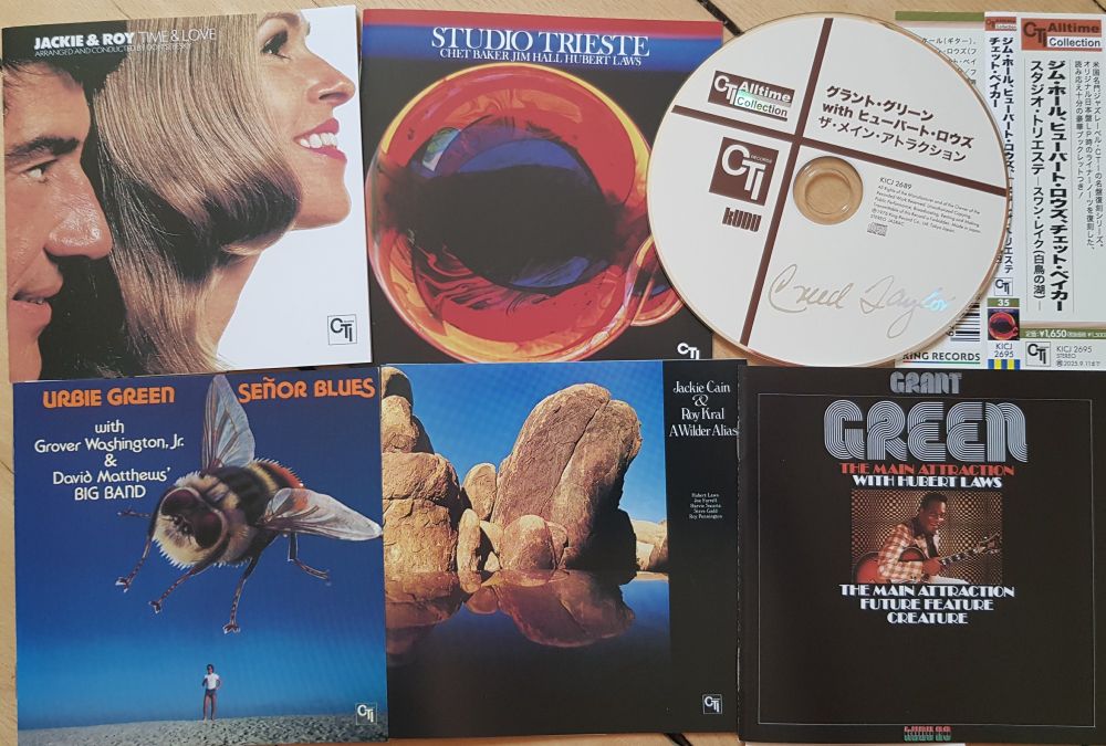 CD booklets and a CD w/japanese print plus an OBI strip on wooden floor. Left to right, top: Jackie & Roy "Time & Love", Chet Baker/Jim Hall/Hubert Laws "Studio Trieste", bottom left to right: Urbie Green "Señor Blues", Jackie & Roy "A Wilder Alias", Grant Green "The Main Attraction".